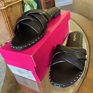 Black flat open-toe sandals with silver accents